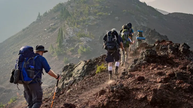 Men climbing a mountain symbolizing a prayer for courage to face life challenges