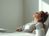 A person sitting at an office desk on Monday morning, appearing peaceful and centered during a quiet moment of prayer.