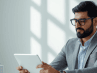 A person calmly reviewing financial information on a tablet in a bright, minimalist office setting.